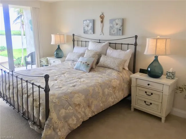 a bedroom with a bed a dresser and next to a window