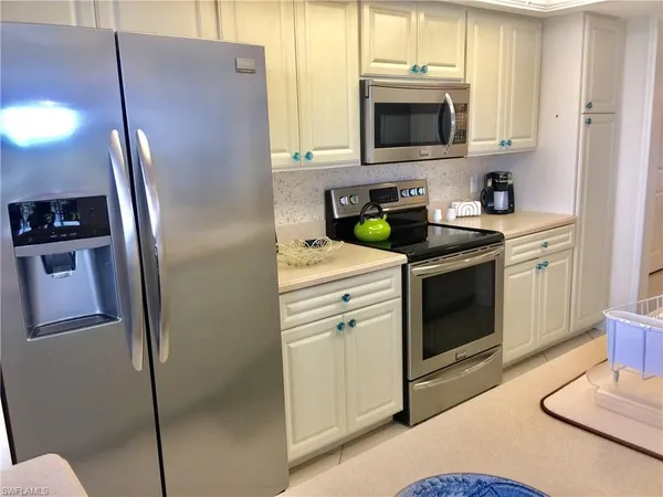 a kitchen with stainless steel appliances granite countertop a refrigerator and a stove top oven