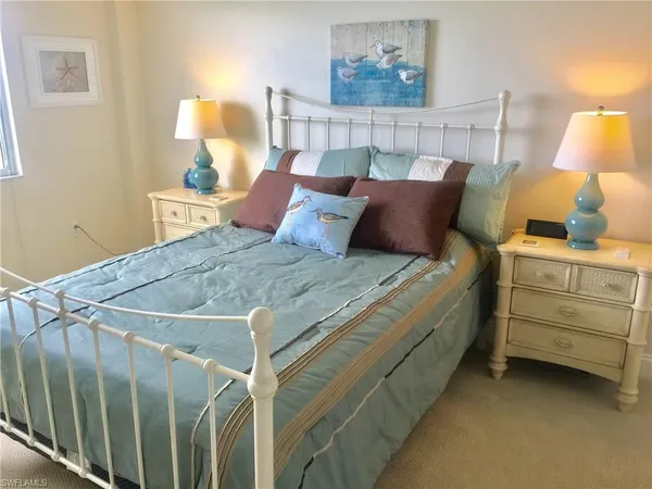 a bed sitting in a bedroom next to a lamp