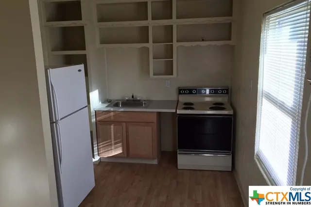 a kitchen with a refrigerator and a stove