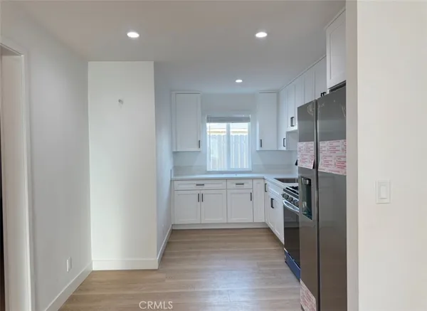 an empty room with wooden floor and entrance