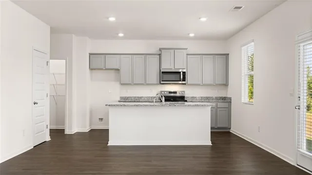 a kitchen with stainless steel appliances a white stove top oven a sink and a window