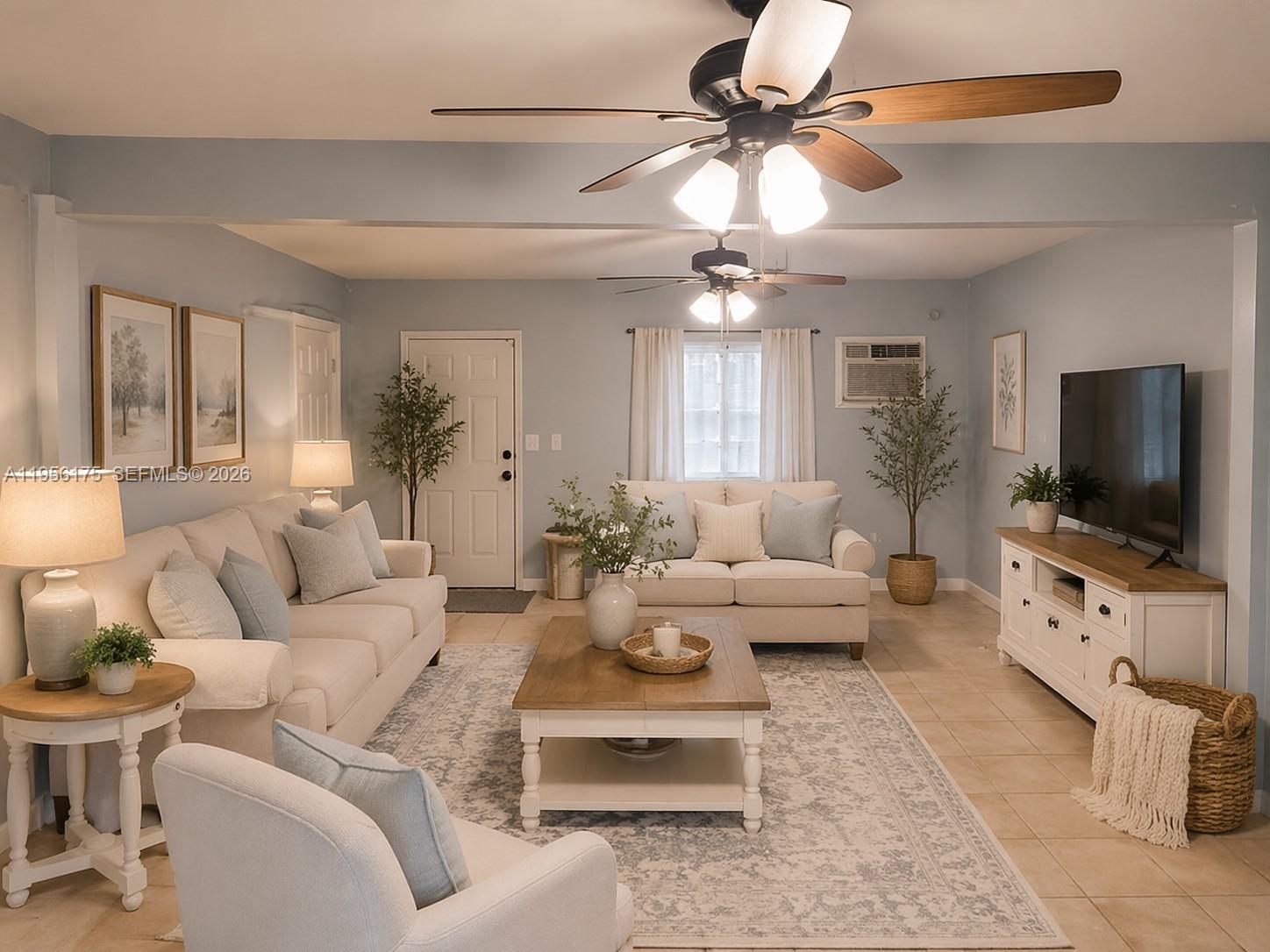 a living room with furniture a flat screen tv and a chandelier