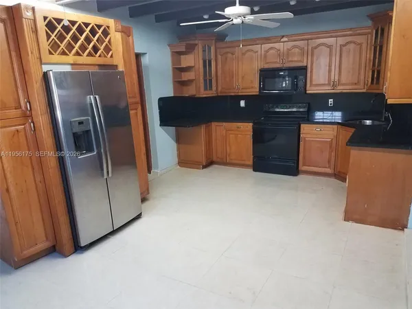 a kitchen with stainless steel appliances granite countertop a refrigerator a stove and a sink with wooden floor