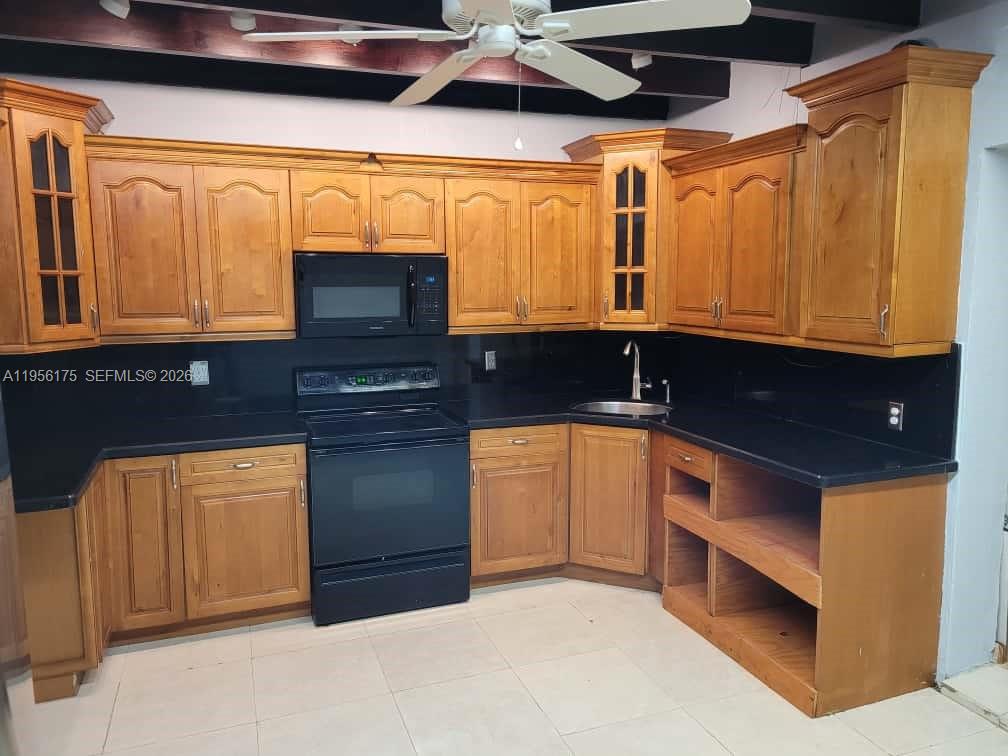 2828 Southwest 3rd Street, Unit FRONT Miami, FL 33135 - Photo 5 of 8 a kitchen with stainless steel appliances granite countertop a sink a stove and a microwave oven