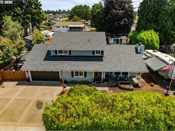 an aerial view of a house with swimming pool and large trees