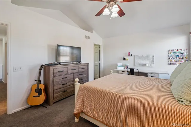 a bedroom with a bed and a flat tv screen on dresser