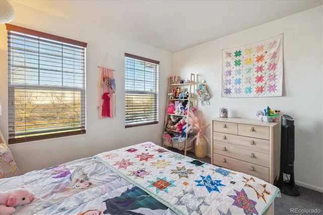 a bedroom with a bed dresser and window