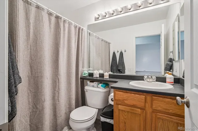a bathroom with a granite countertop sink toilet and mirror