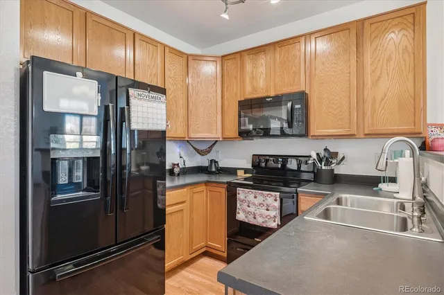 a kitchen with granite countertop a refrigerator stove and sink