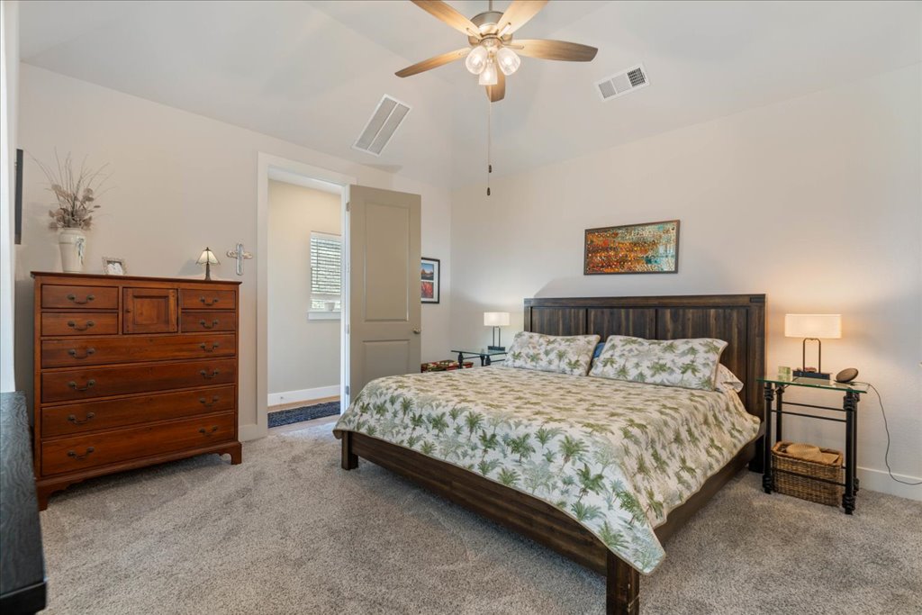 7912 Prairie Rye Drive Lago Vista, TX 78645 - Photo 16 of 37 Spacious primary bedroom retreat featuring a vaulted ceiling and a beautiful bay window that fills the room with natural light. Ensuite bath access and a serene atmosphere make this the perfect place to unwind.