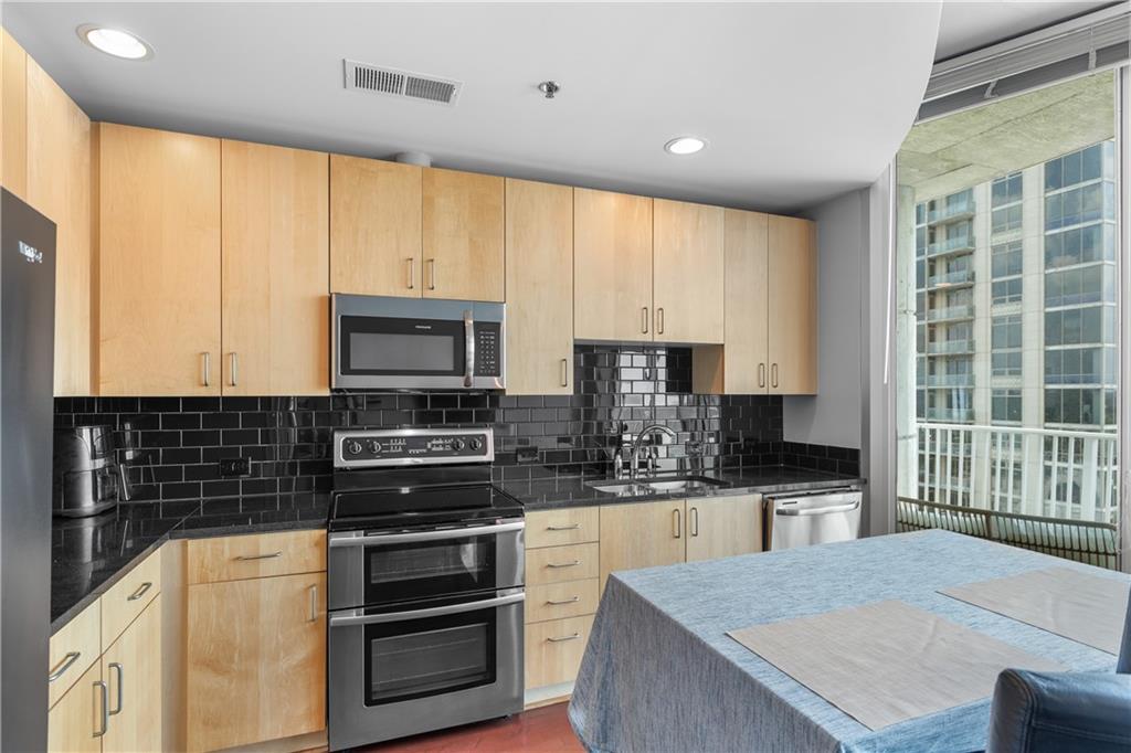 361 17th Street Northwest, Unit 2115 Atlanta, GA 30363 - Photo 11 of 24 a kitchen with stainless steel appliances a stove sink microwave and cabinets
