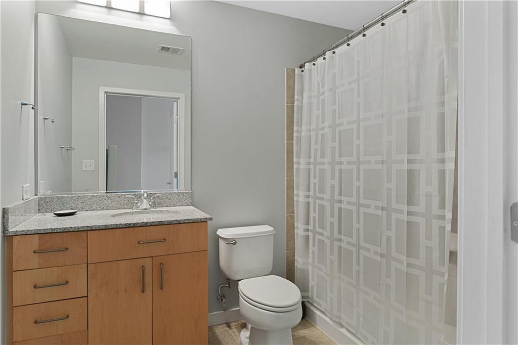 361 17th Street Northwest, Unit 2115 Atlanta, GA 30363 - Photo 15 of 24 a bathroom with a granite countertop sink a toilet and a mirror