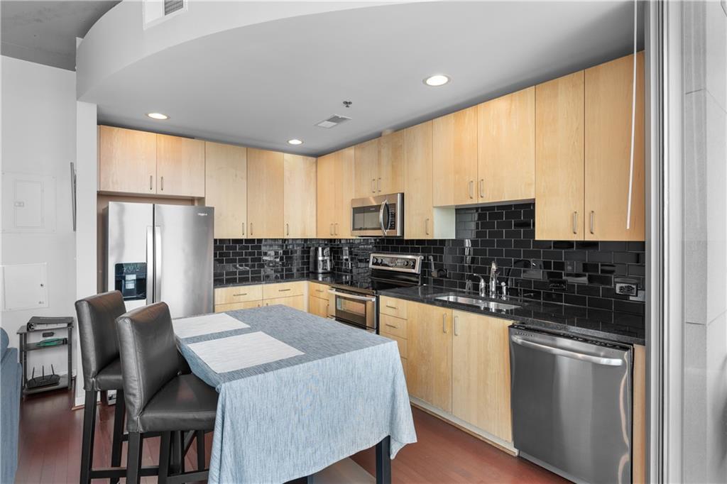 361 17th Street Northwest, Unit 2115 Atlanta, GA 30363 - Photo 9 of 24 a kitchen with stainless steel appliances granite countertop a stove a sink a microwave a dining table and chairs