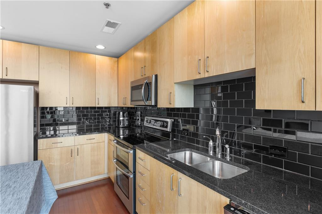 361 17th Street Northwest, Unit 2115 Atlanta, GA 30363 - Photo 10 of 24 a kitchen with granite countertop a sink a stove and cabinets