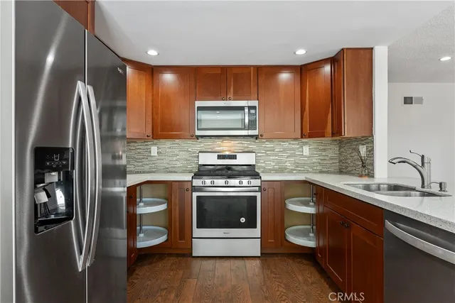a kitchen with stainless steel appliances granite countertop a stove a sink and a refrigerator