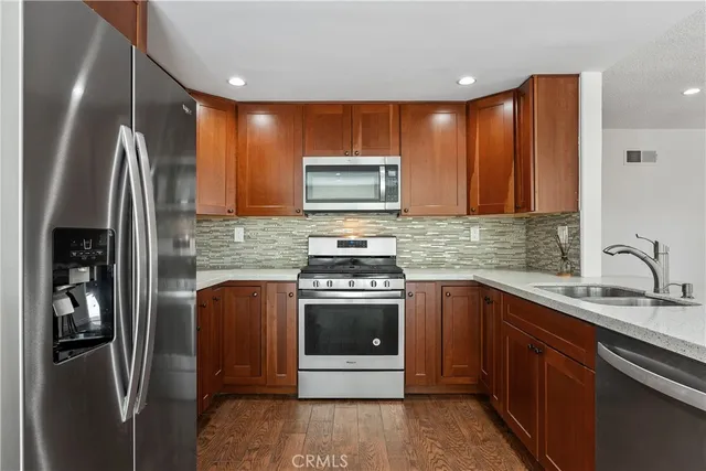 a kitchen with stainless steel appliances granite countertop a stove a sink and a refrigerator