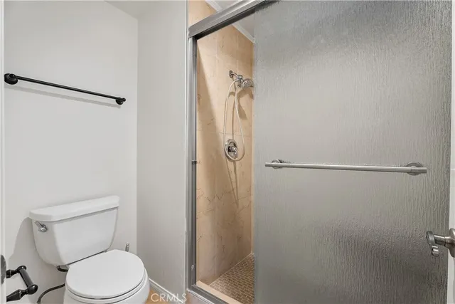 a white toilet sitting next to a shower