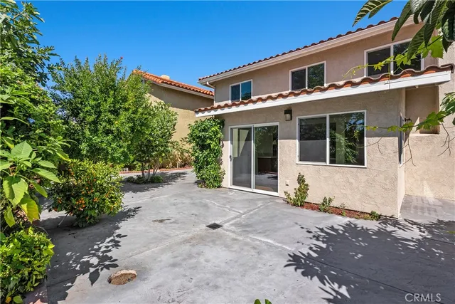 a front view of a house with a yard and potted plants