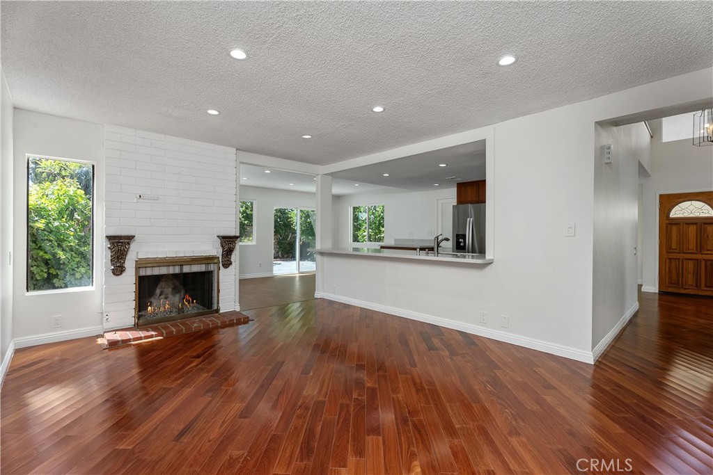 30 Entrada West Irvine, CA 92620 - Photo 8 of 41 a view of a big room with wooden floor a fireplace and windows