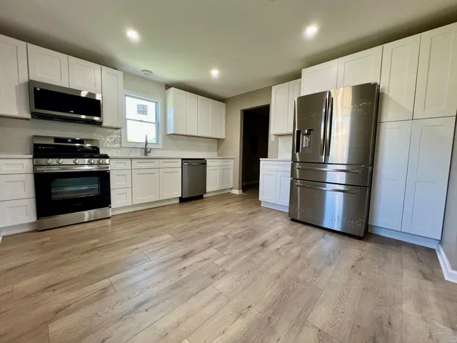 a kitchen with stainless steel appliances granite countertop a refrigerator microwave and stove top oven