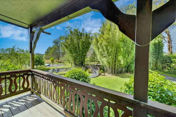 a balcony with wooden floor outdoor seating and yard