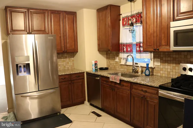 a kitchen with stainless steel appliances granite countertop a refrigerator sink and cabinets