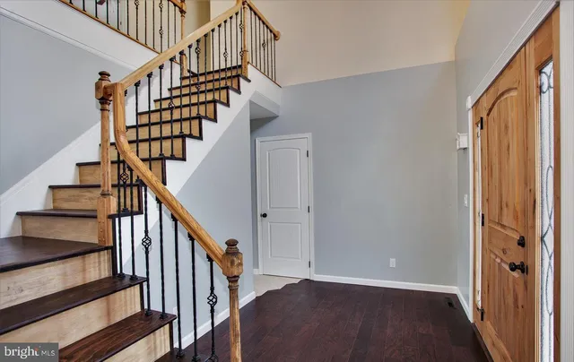 a view of staircase with lots of frames on wall and a window