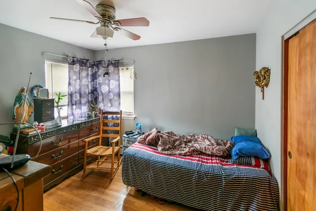 a bedroom with a bed and wooden floor