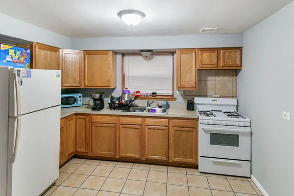 a kitchen with a refrigerator sink and cabinets