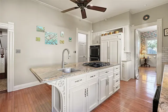 a kitchen with granite countertop a stove a sink and a microwave