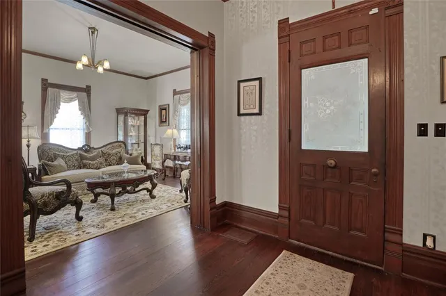 a view of a hallway with wooden floor and stairs
