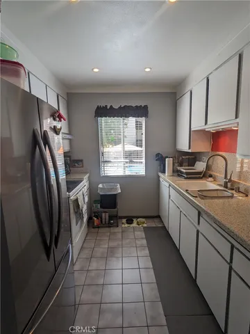 a kitchen with a refrigerator a stove a sink and a window