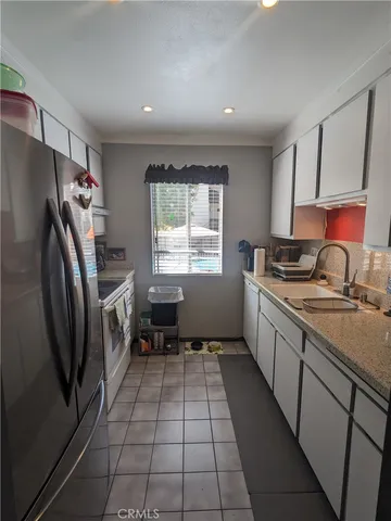 a kitchen with a sink a refrigerator and window
