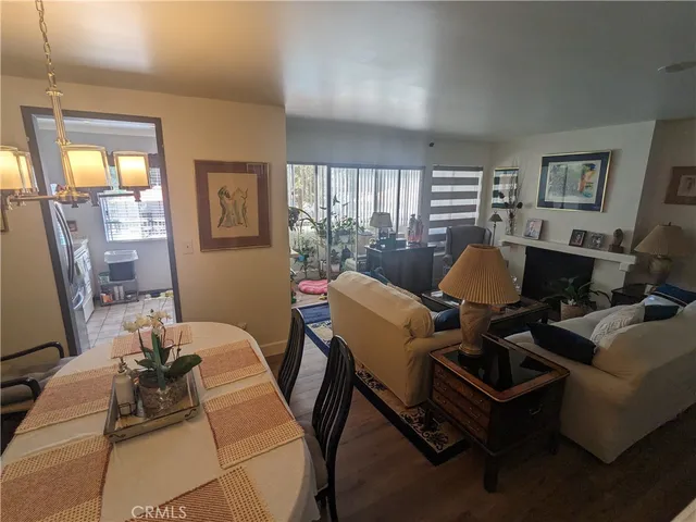 a living room with furniture a lamp wooden floor and a large window
