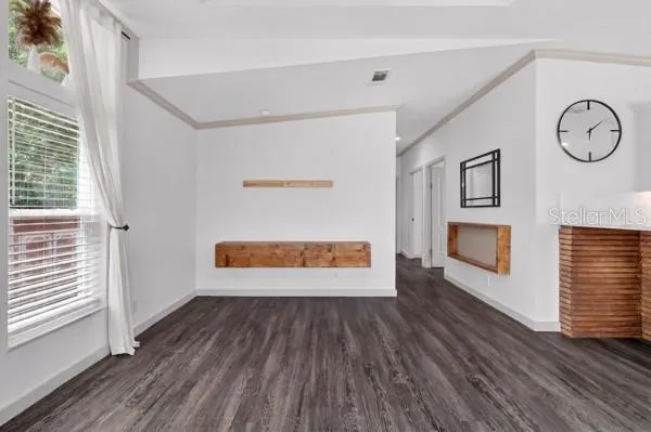 a view of a kitchen from the hallway with wooden floor