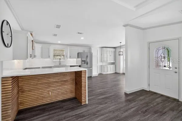 a kitchen with stainless steel appliances granite countertop a sink cabinets and wooden floor