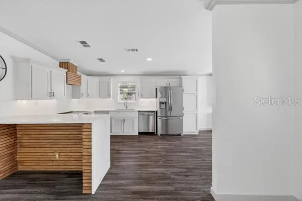 a kitchen with white cabinets and stainless steel appliances