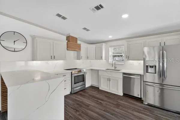 a kitchen with a refrigerator and a stove top oven