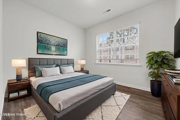 a bedroom with a bed and a potted plant