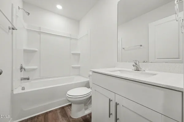 a bathroom with a granite countertop sink a toilet and shower