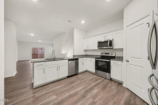a kitchen with granite countertop white cabinets and white appliances