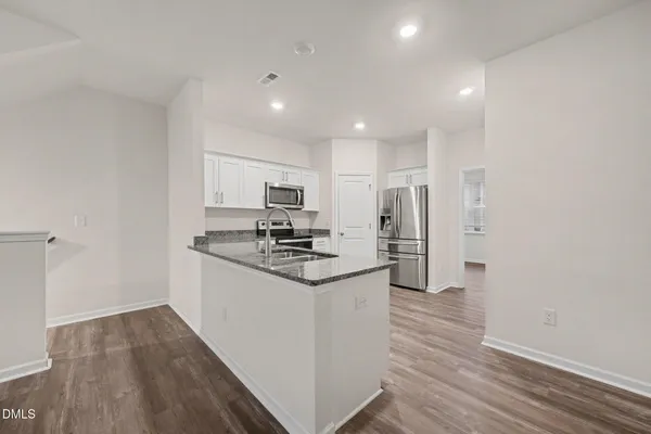 a kitchen with stainless steel appliances a refrigerator and a stove top oven