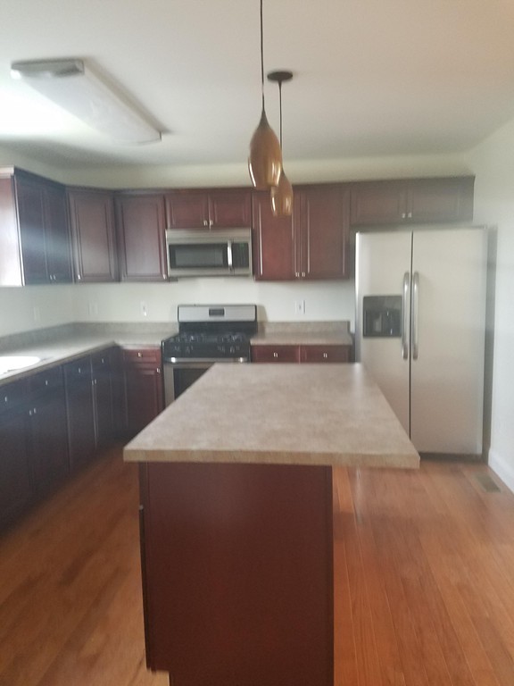 23 Beech Street Springfield, MA 01105 - Photo 3 of 10 a kitchen with stainless steel appliances granite countertop a sink a stove and a refrigerator