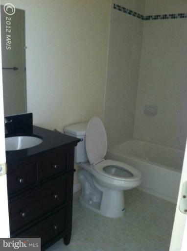233 Arden Road West Baltimore, MD 21225 - Photo 5 of 10 a bathroom with a granite countertop toilet and a sink