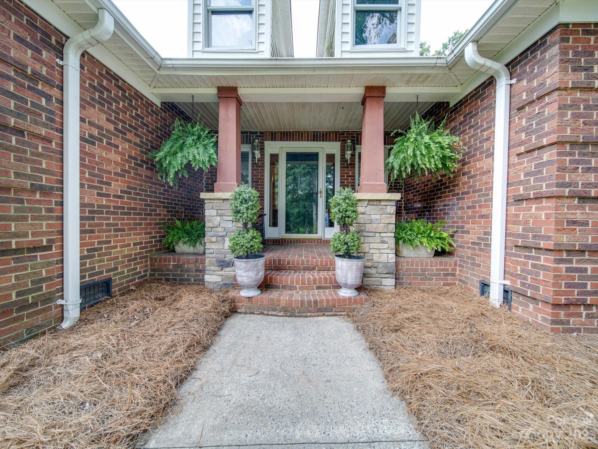 5817 Unionville Road Monroe, NC 28110 - Photo 4 of 46 front view of a brick house with potted plants