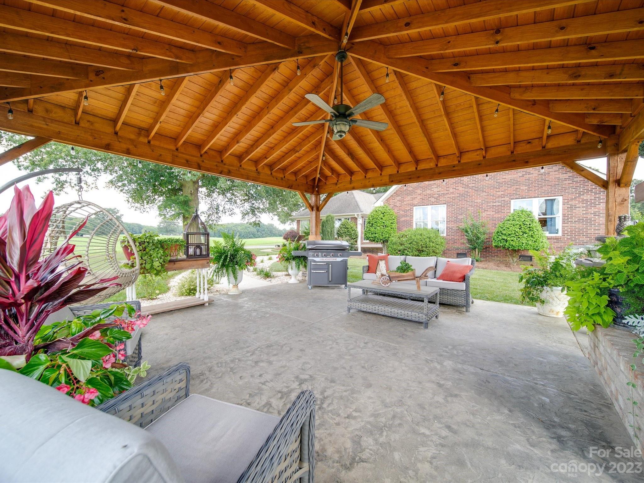 5817 Unionville Road Monroe, NC 28110 - Photo 5 of 46 a view of backyard with a table and chairs under an umbrella