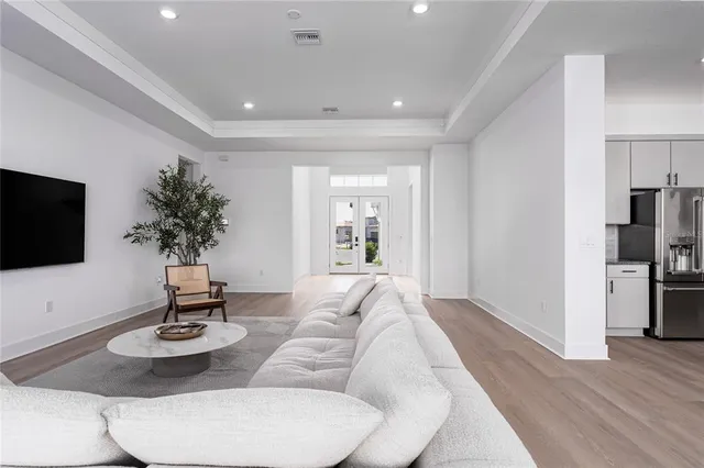 a kitchen with stainless steel appliances granite countertop a table chairs stove and white cabinets