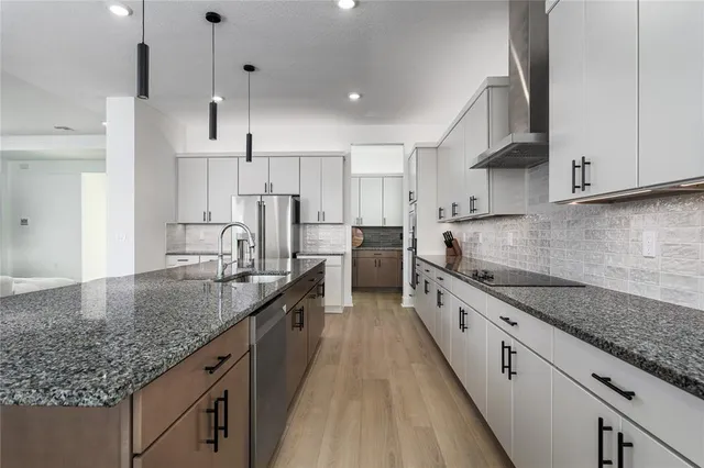 a kitchen with stainless steel appliances granite countertop a stove a sink and a refrigerator