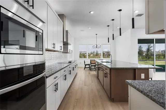 a kitchen with granite countertop a cabinets and a wooden floor
